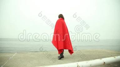孤独的女孩穿着<strong>红毯</strong>看着大海
